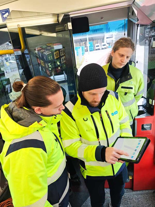 Drei VBZ-Mitarbeiter in einer Tram, einer hat ein Tablet in der Hand und zeigt den beiden anderen etwas