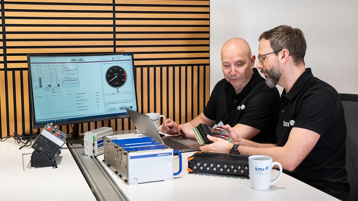 Messdatenerfassung und Beratung durch TMX-Experten Zwei TMX-Mitarbeiter arbeiten mit mehreren Messdatenerfassungssystemen